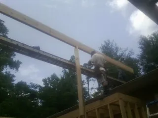 Carpenter setting a ridge beam over a new addition frame — Ice Dam Removal by Roofing Brothers in La Crescent