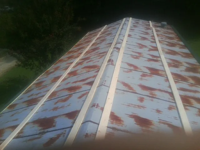 Rusted metal roof panels with new wood purlins before replacement — Storm Damage Roof Repair in La Crescent by Roofing Brothers