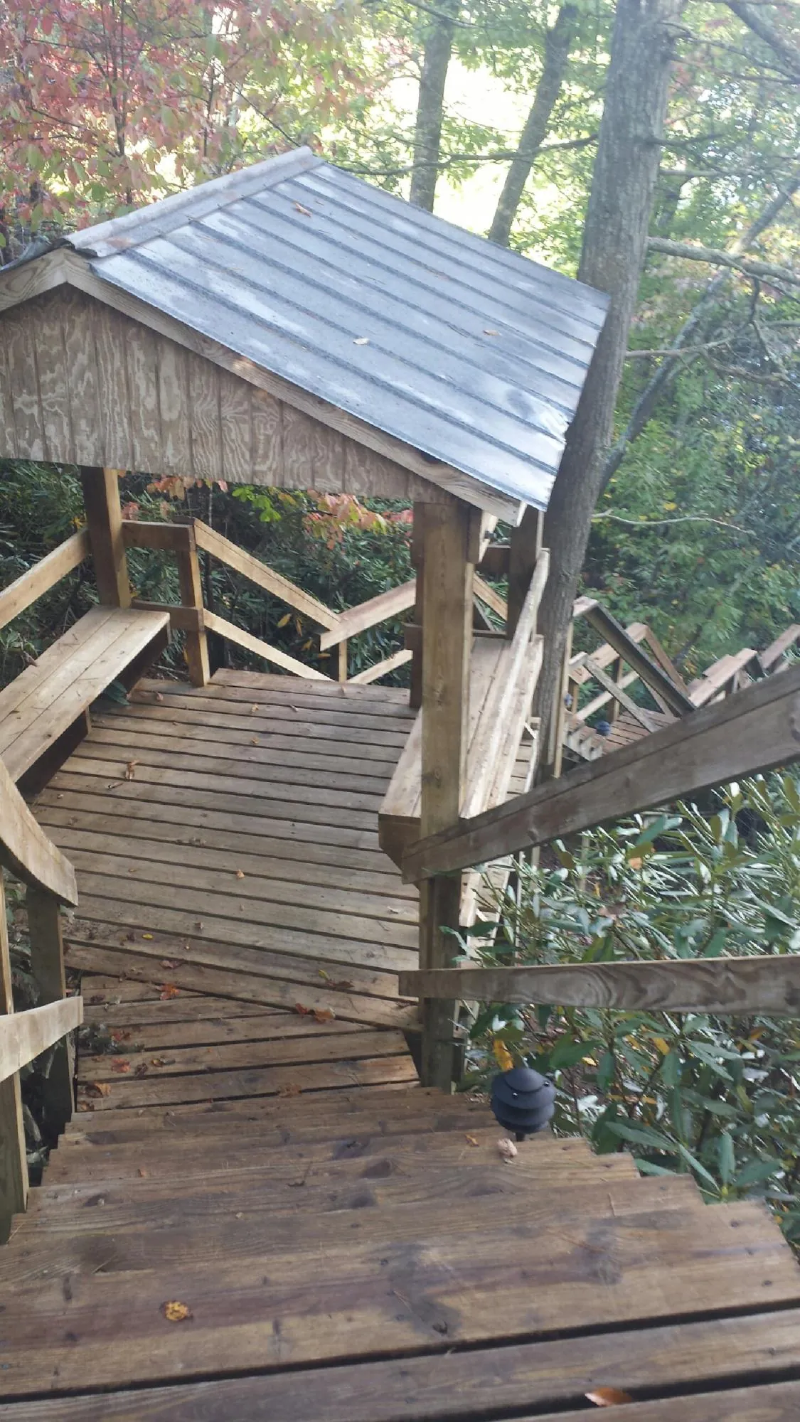 Metal roofed shelter over wooden steps on a wooded walkway — Skylight Repair & Installation work by our crew in La Crescent