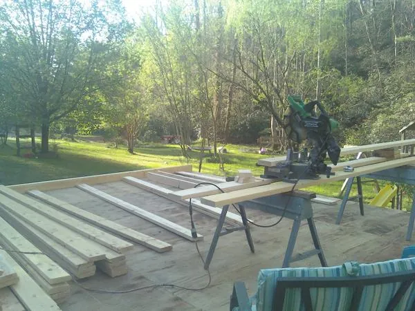Miter saw and framing lumber on a deck under construction in La Crescent