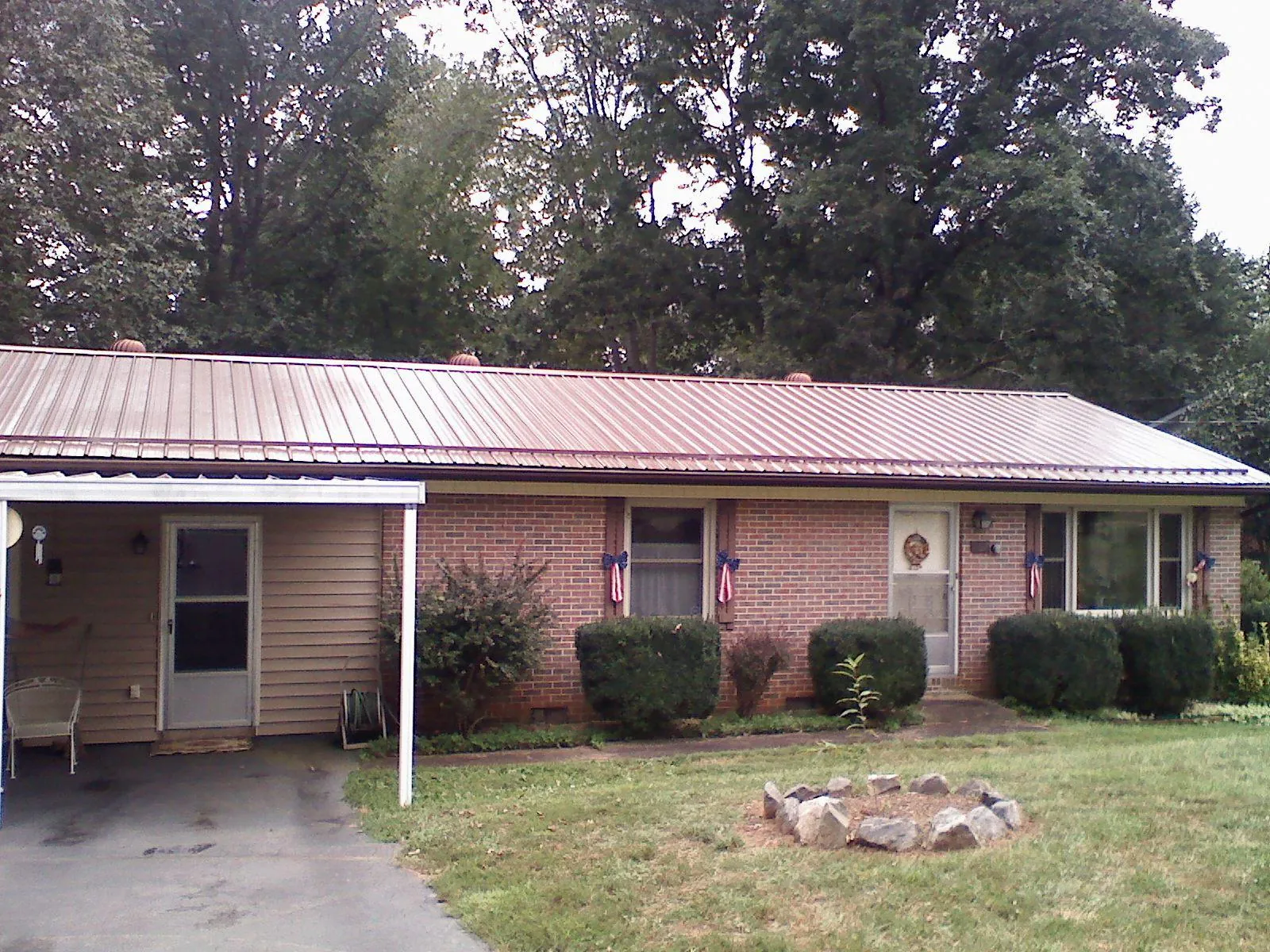 Bronze metal roof and carport on a brick ranch home — Roof Repair work by our crew in La Crescent